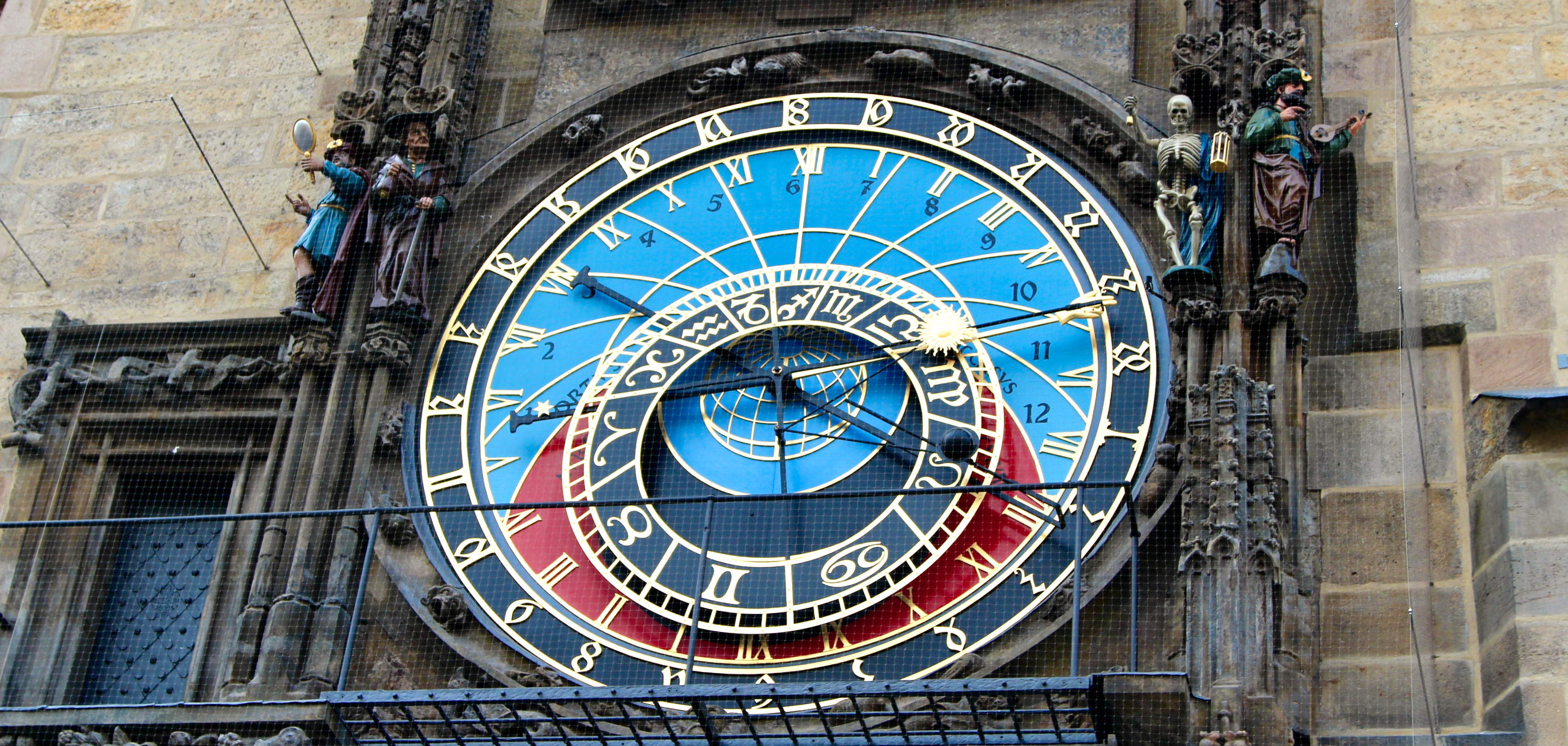 A close-up shot of the Astronomical Clock in Prague shows the multitude of different hands, numbers, and symbols used for tracking many different kinds of time.