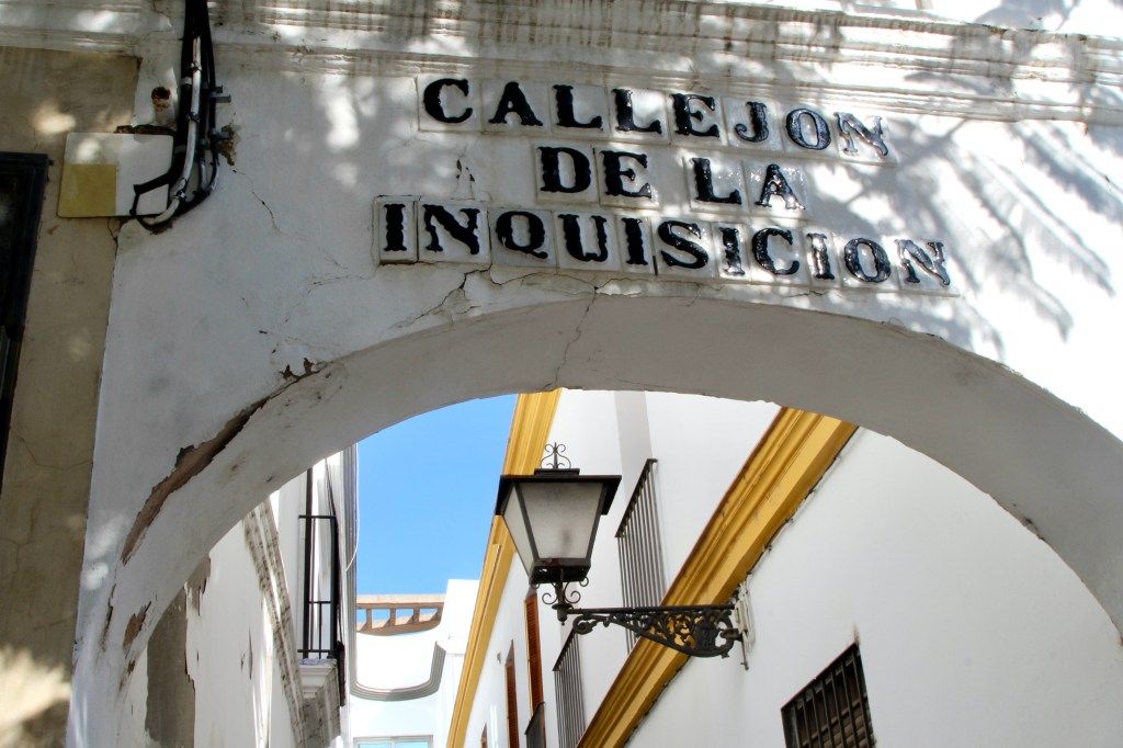 Lettering above an archway reads "Callejon de la Inquisicion."